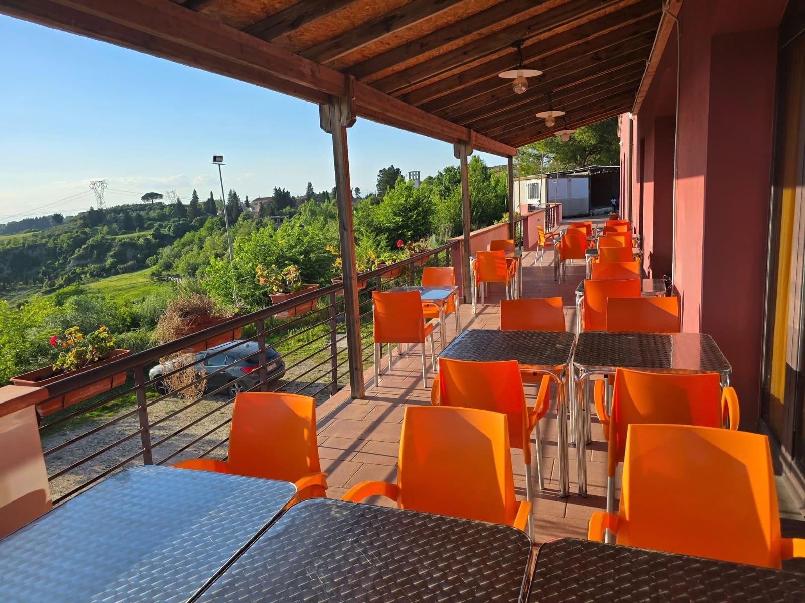 La terrazza coperta di I'Poggio, con i tavoli sotto la tettoia in legno affacciati sulla campagna toscana